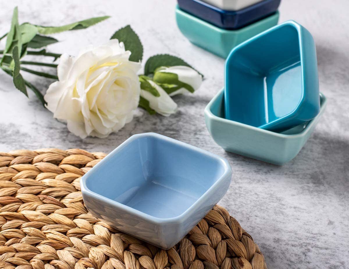 small bowls next to a white rose on a gray background