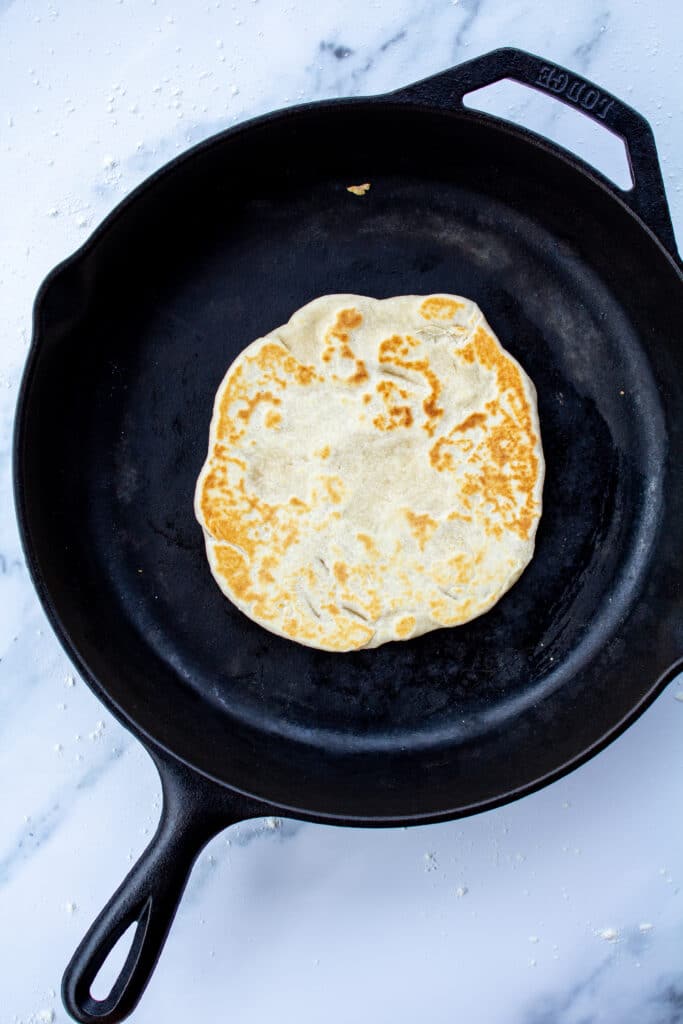 cooked tortilla in cast iron skillet