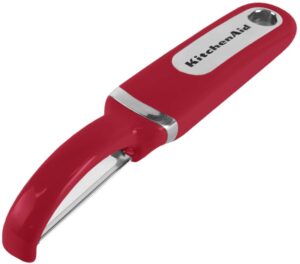 A red vegetable peeler laying face-down 