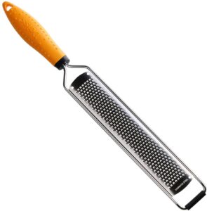 A silver zester with an orange handle